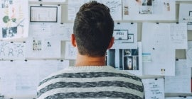 researcher looking at a wall of diagrams and charts