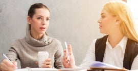 two students talking in a meeting